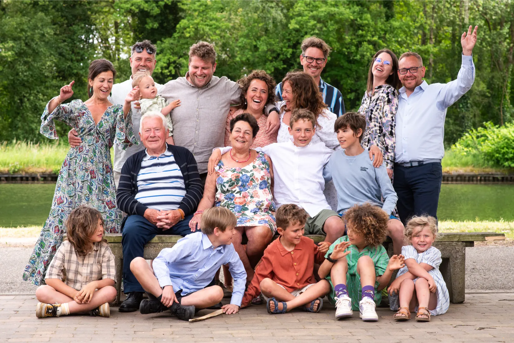 Vrolijke familiefoto met grootouders, kinderen en kleinkinderen aan het water – ontspannen groepsportret op locatie.