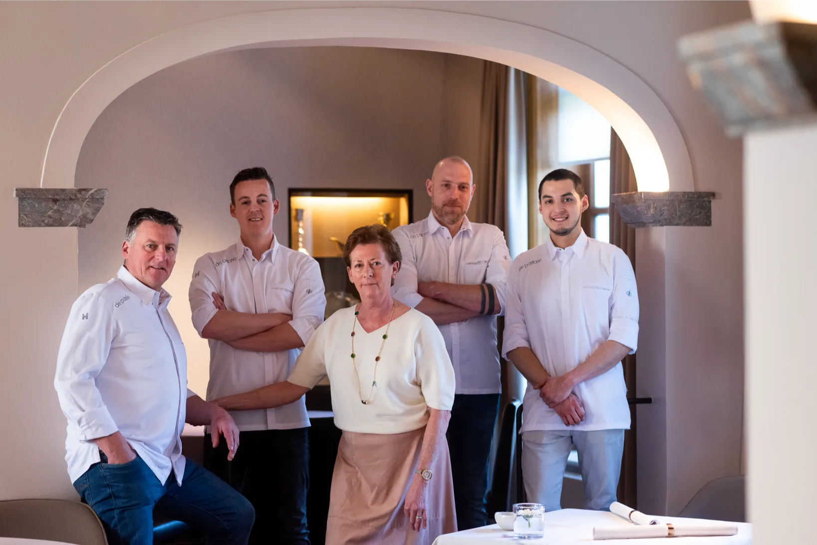 Restaurantteam in uniforme kledij, professioneel gefotografeerd in sfeervolle zaak