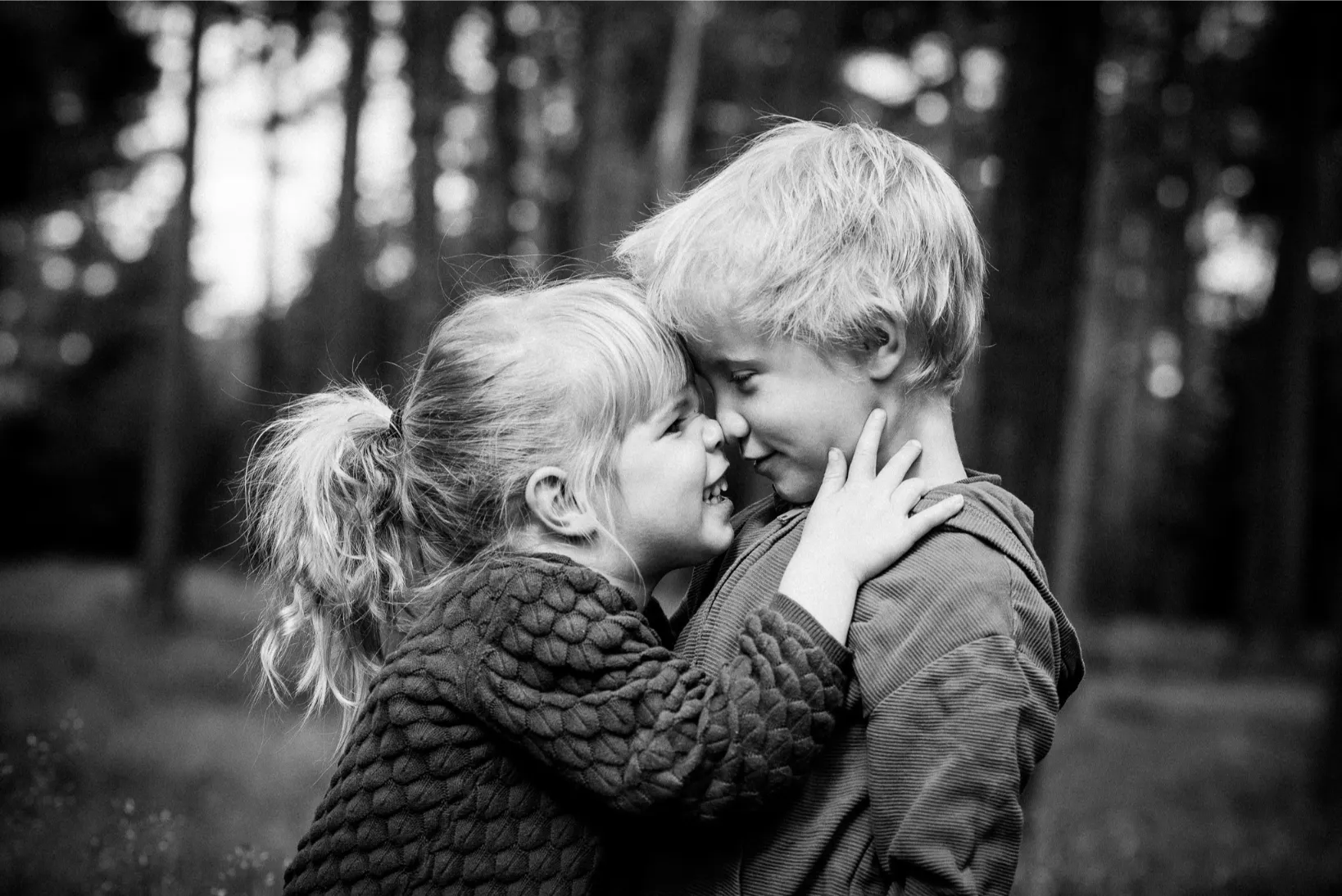 Emotioneel kinderportret in de natuur: broer en zus in een liefdevolle omhelzing