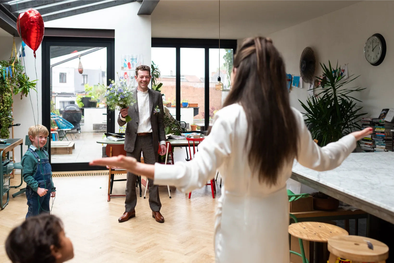 Eerste blikmoment thuis: kinderen, bloemen en échte emoties bij het begin van een trouwdag.